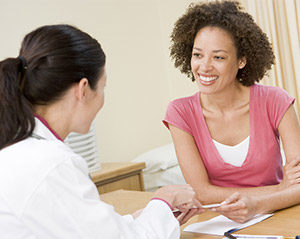Doctor at desk with patient sharing information.