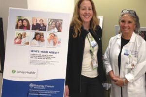 Two officials at Lahey Health standing near Who's Your Agent Poster