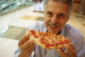 Man eating pizza at a Pizza and Proxy event