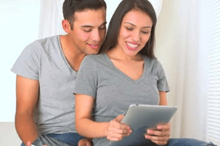 couple viewing information Younger couple looking at a large mobile device together.