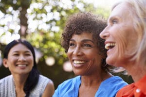 A group of three older women talking and laughing.